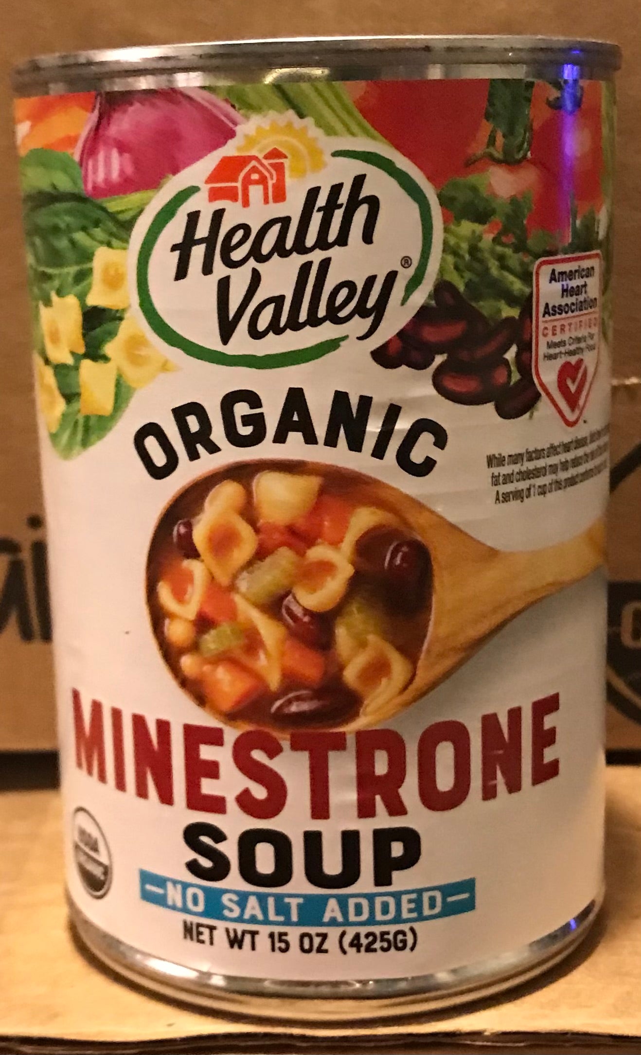 Can of Health Valley Organic Minestrone Soup with a wooden spoon in the center.