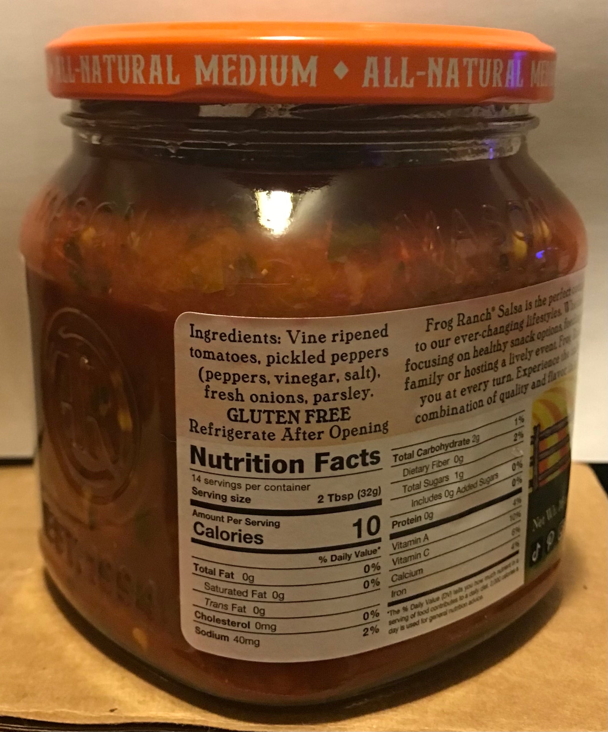 Jar of salsa with a visible nutrition label on an orange surface