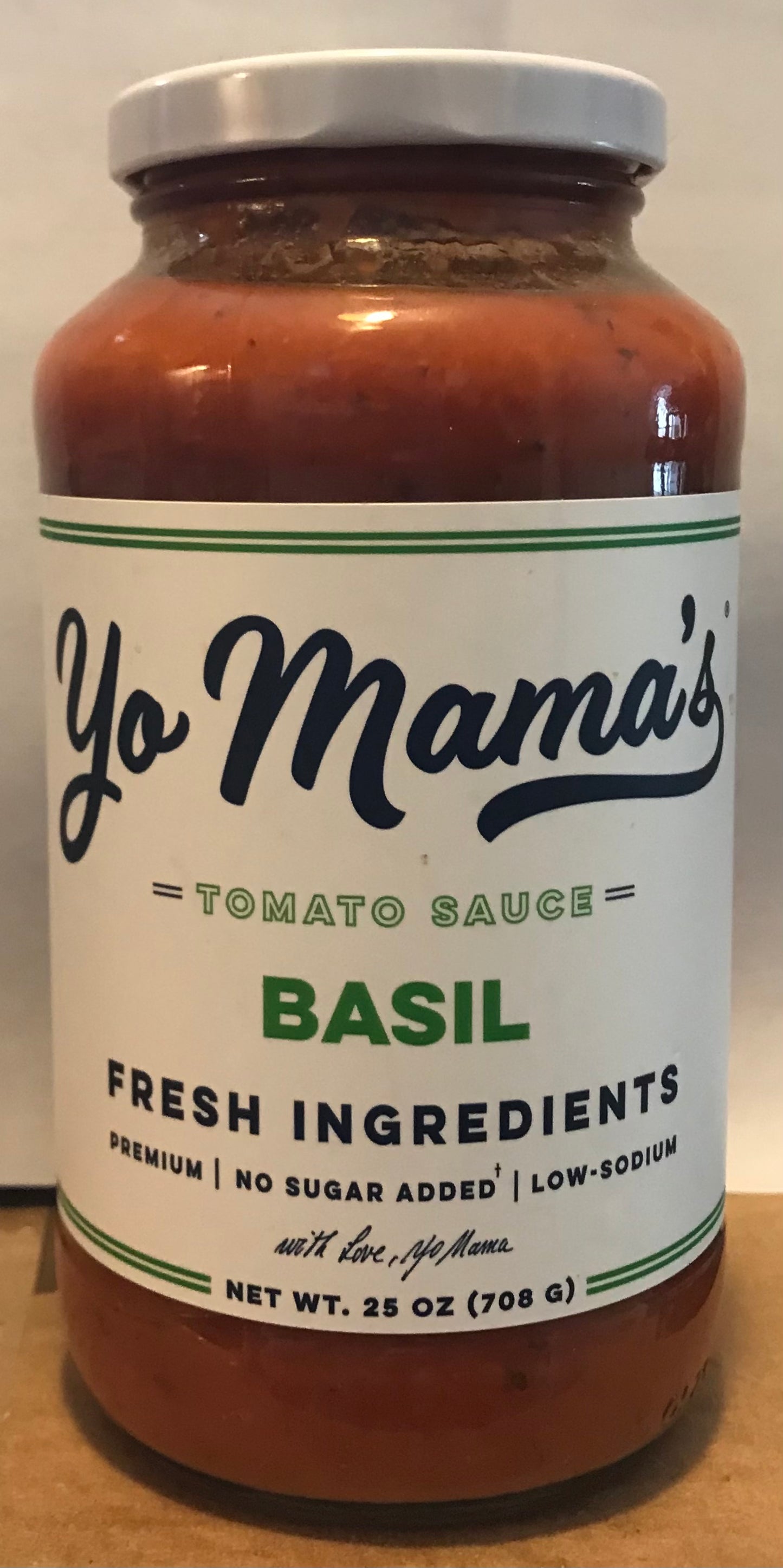 Jar of Yo Mama's Basil Tomato Sauce on a wooden surface